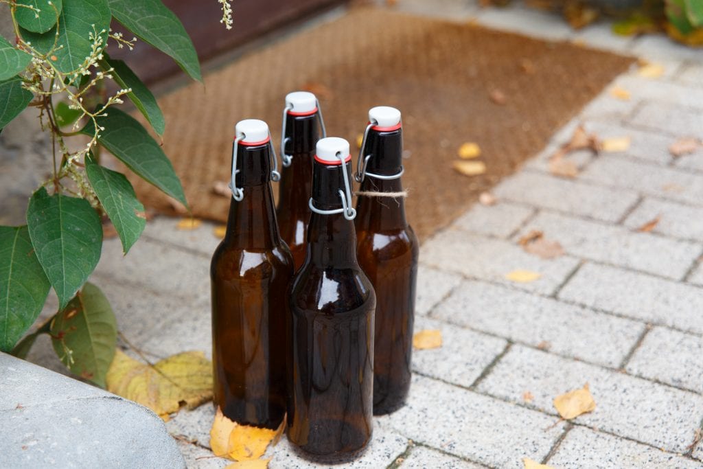 Four empty beer bottles on porch of house