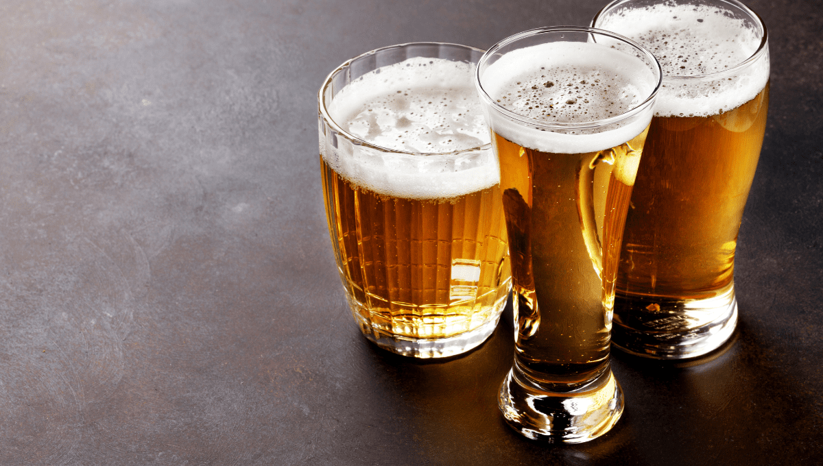 Three glasses of light lager and pilsner beer on a dark surface, showing clear color and carbonation differences between beer types