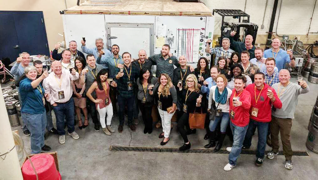 A large group of City Brew Tours guests pose for a picture on their company outing