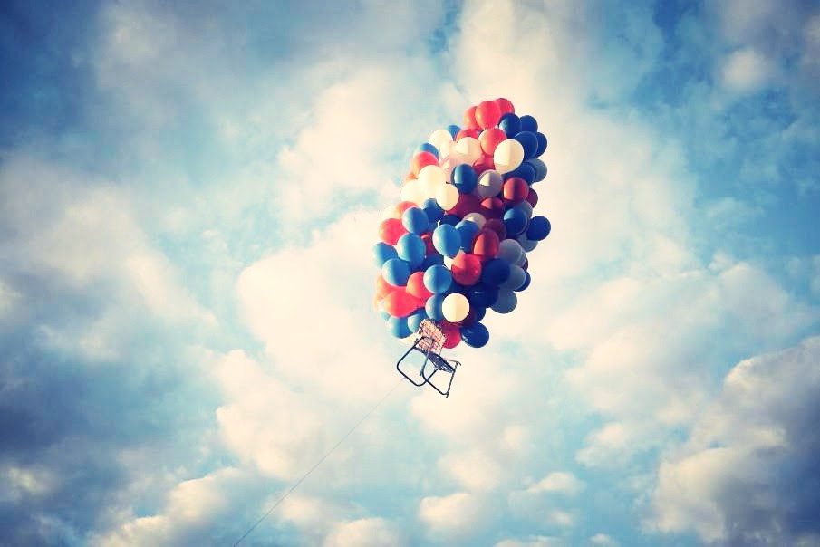 Aeronaut Cannery photo of balloons attached to lawn chair floating in the sky