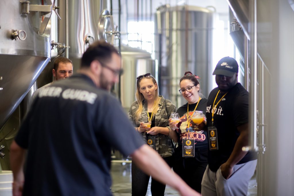 A beer guide leads a behind-the-scenes tour of a local brewery