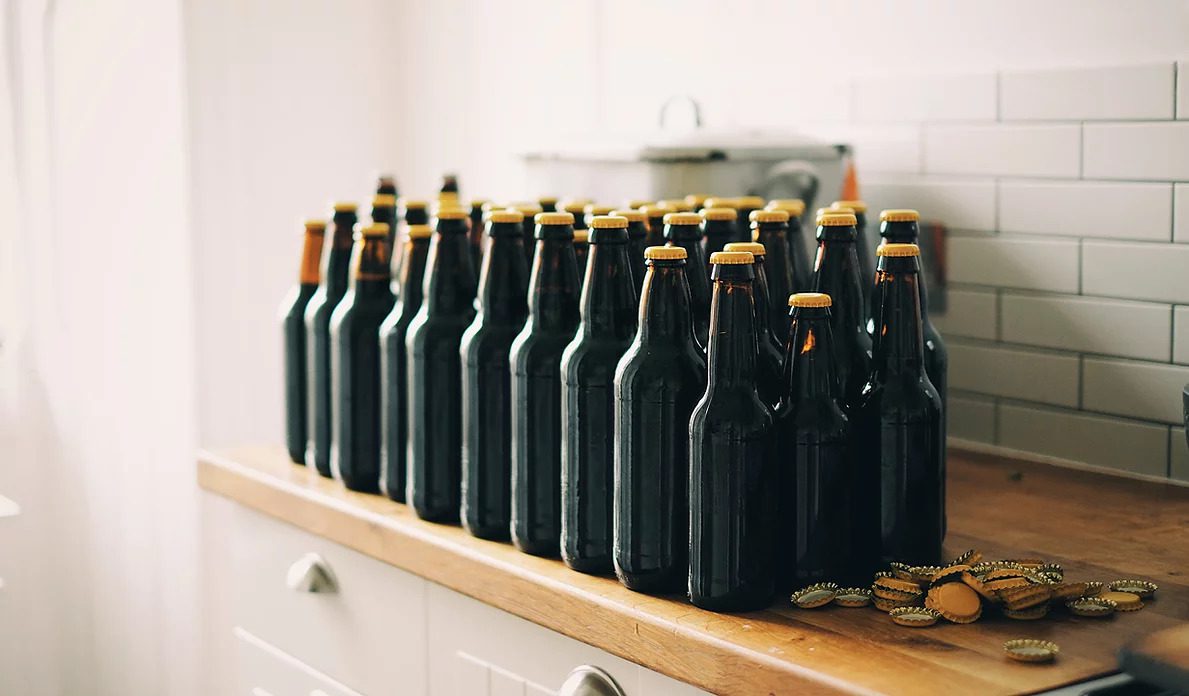 Dark beer bottles sit on a shelf