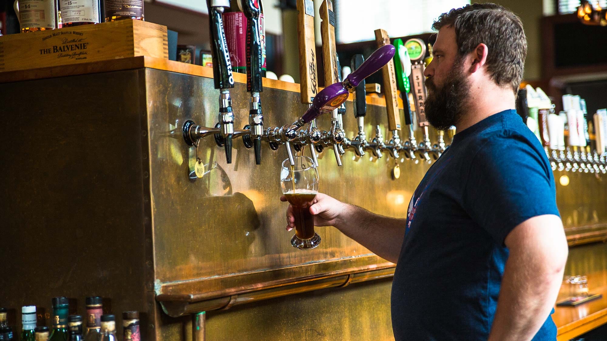 A bartender pouring a draft beer during a City Brew Tour