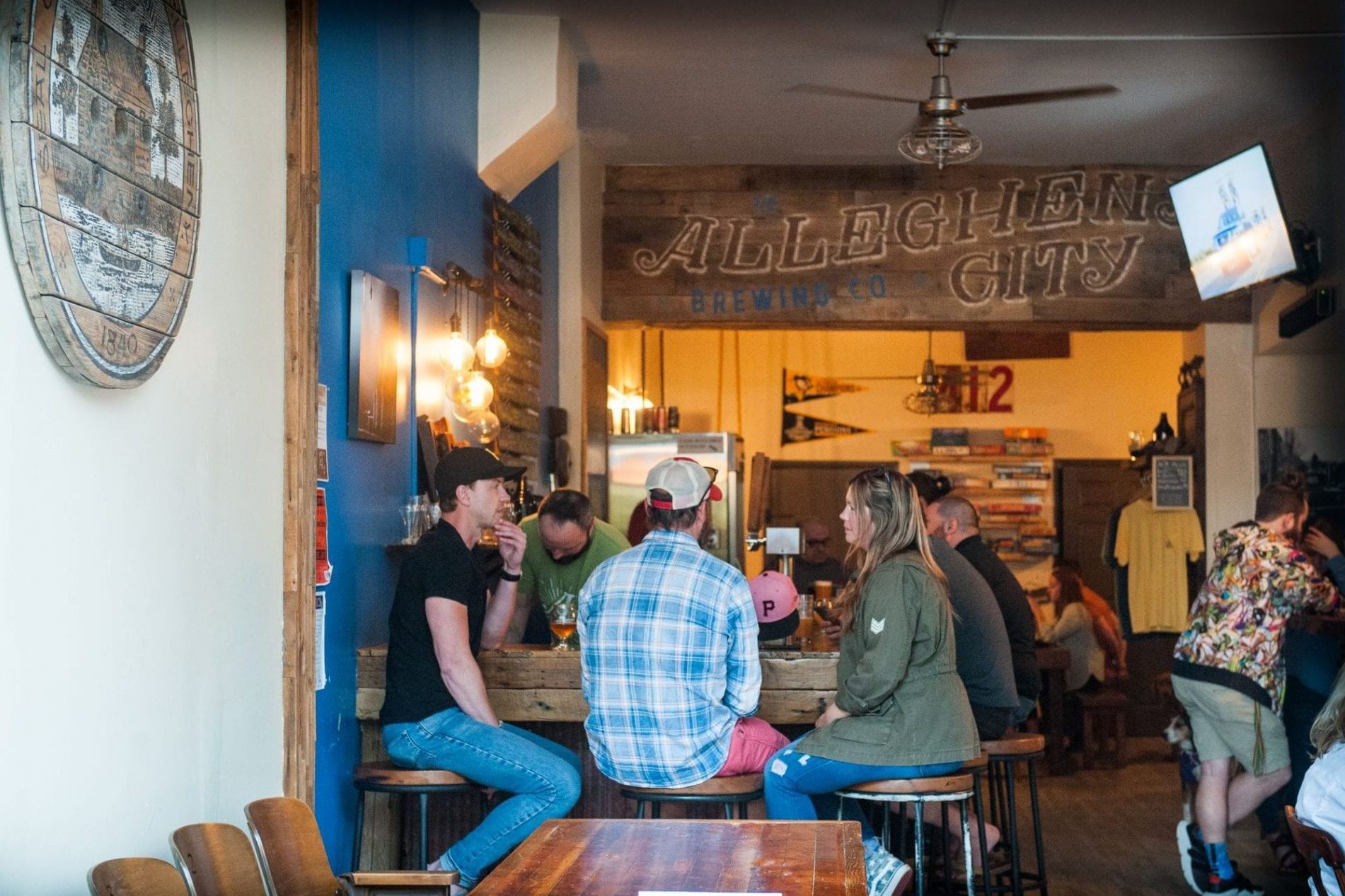 A group of brew tour guests sit inside Allegheny City's taproom in Pittsburgh, PA